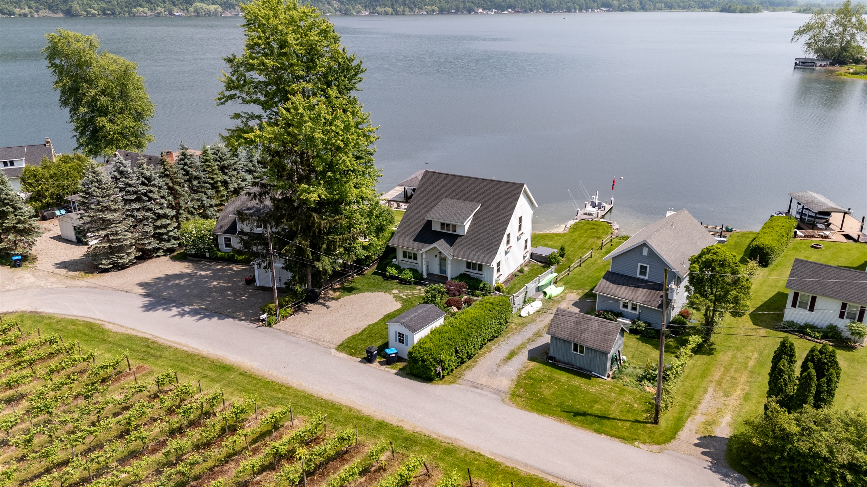 Stunning aerial view of a serene Finger Lakes waterfront retreat, complete with private dock, lush greenery, and charming lakefront homes—perfect for peaceful getaways and water adventures