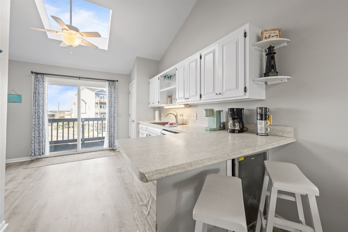 Kitchen with breakfast bar seating, perfect for morning coffee or quick bites before heading out to the beach