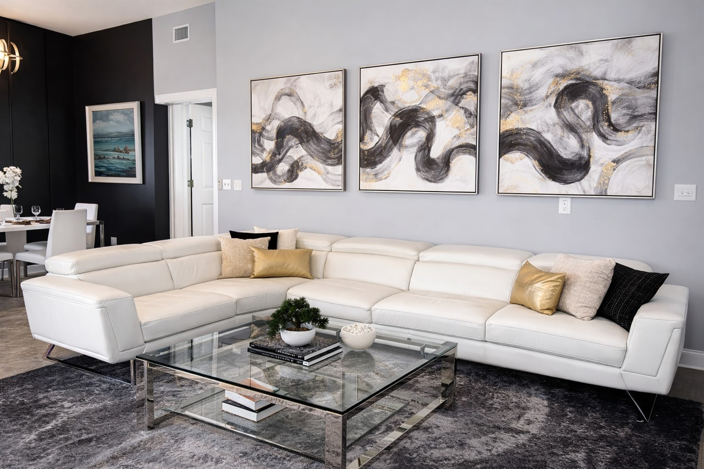 Modern living room with a large white sectional sofa and abstract wall art