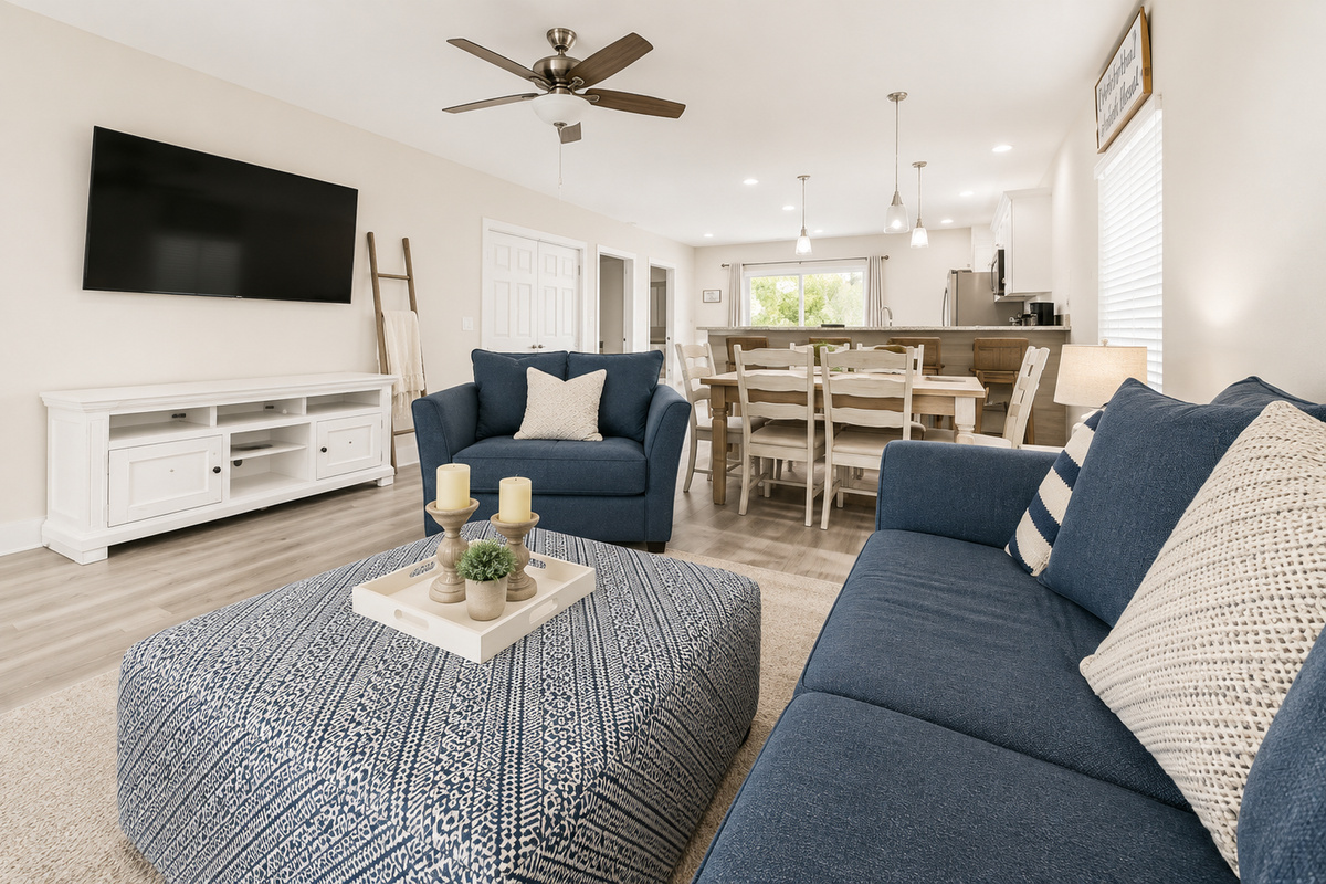 From movie night to board games, the open living room keeps the whole family in one easy orbit — sectional and swivel chair around the TV, the dining table steps away, and the kitchen close enough to field snack requests.
