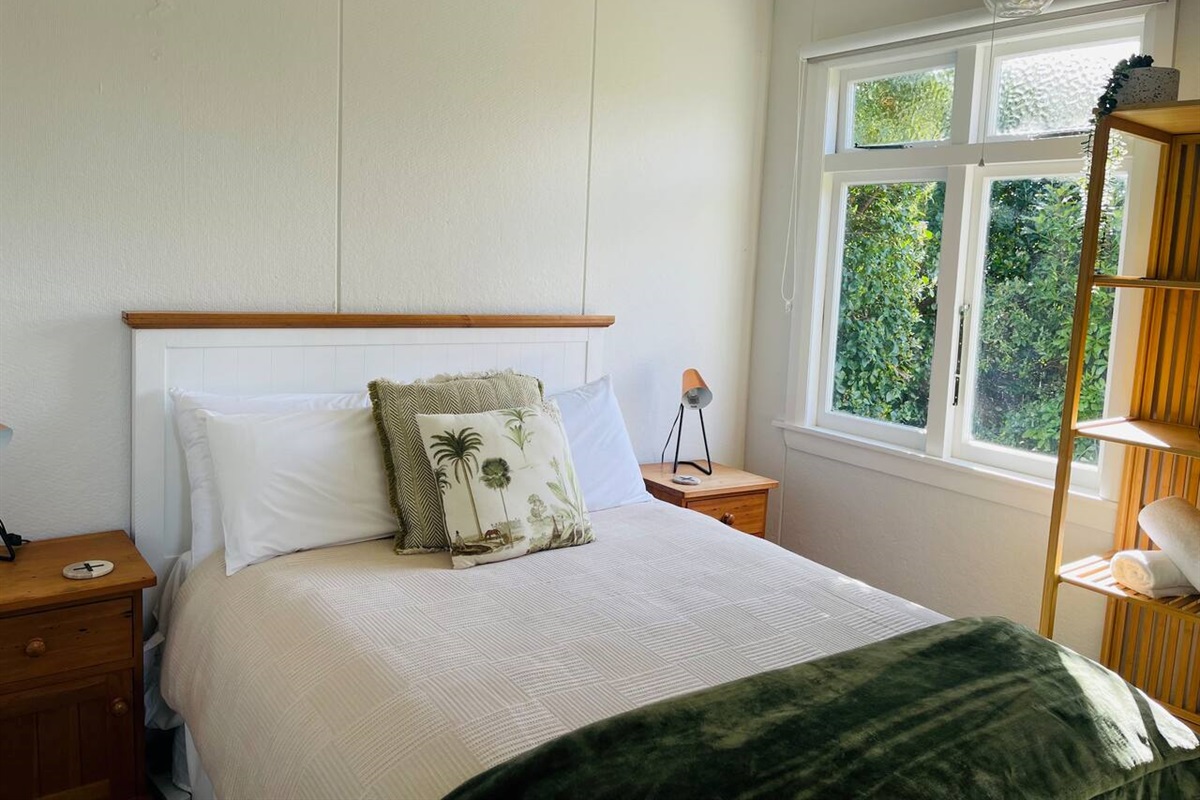 Bedroom 2 has a generous double bed with a nice comfy mattress topper, bedside table lamps for that cozy bedtime read, an eco heater to keep you nice and warm in winter and a soothing bush clad view.