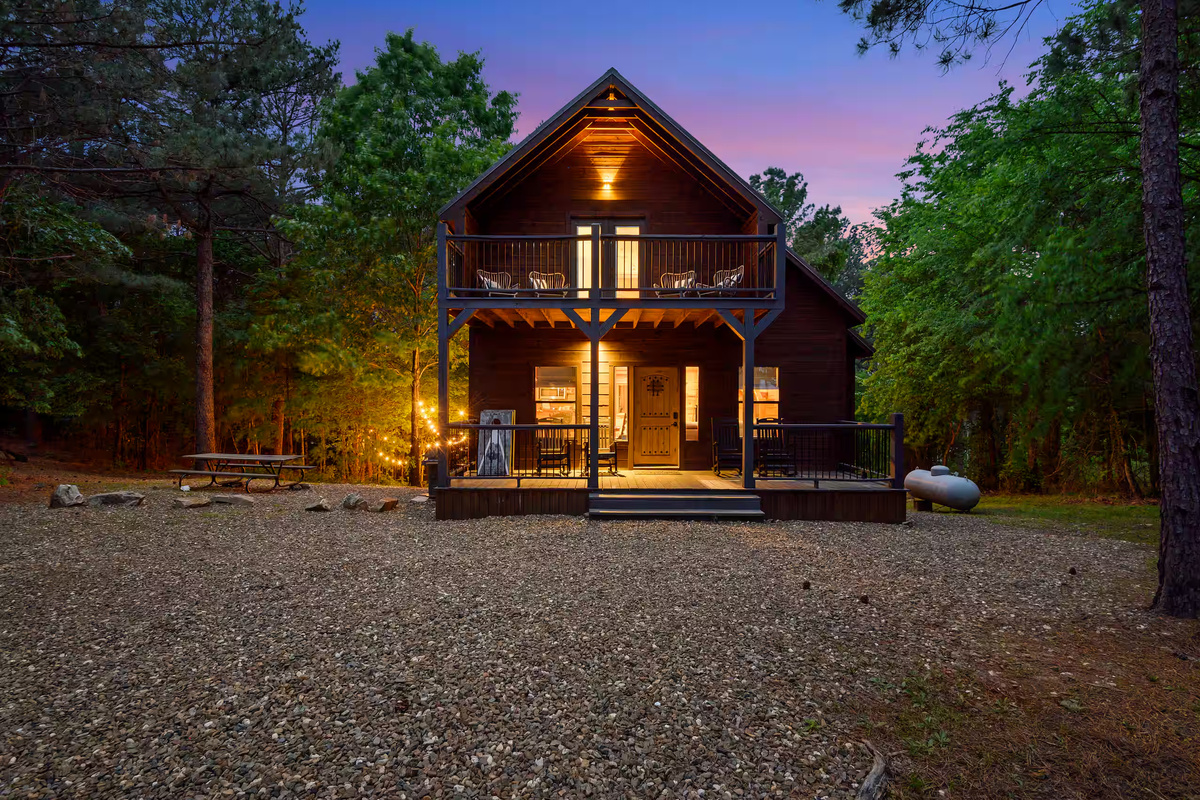 Charming Cabin Exterior: Enjoy serene evenings on the porch with nature as your backdrop!