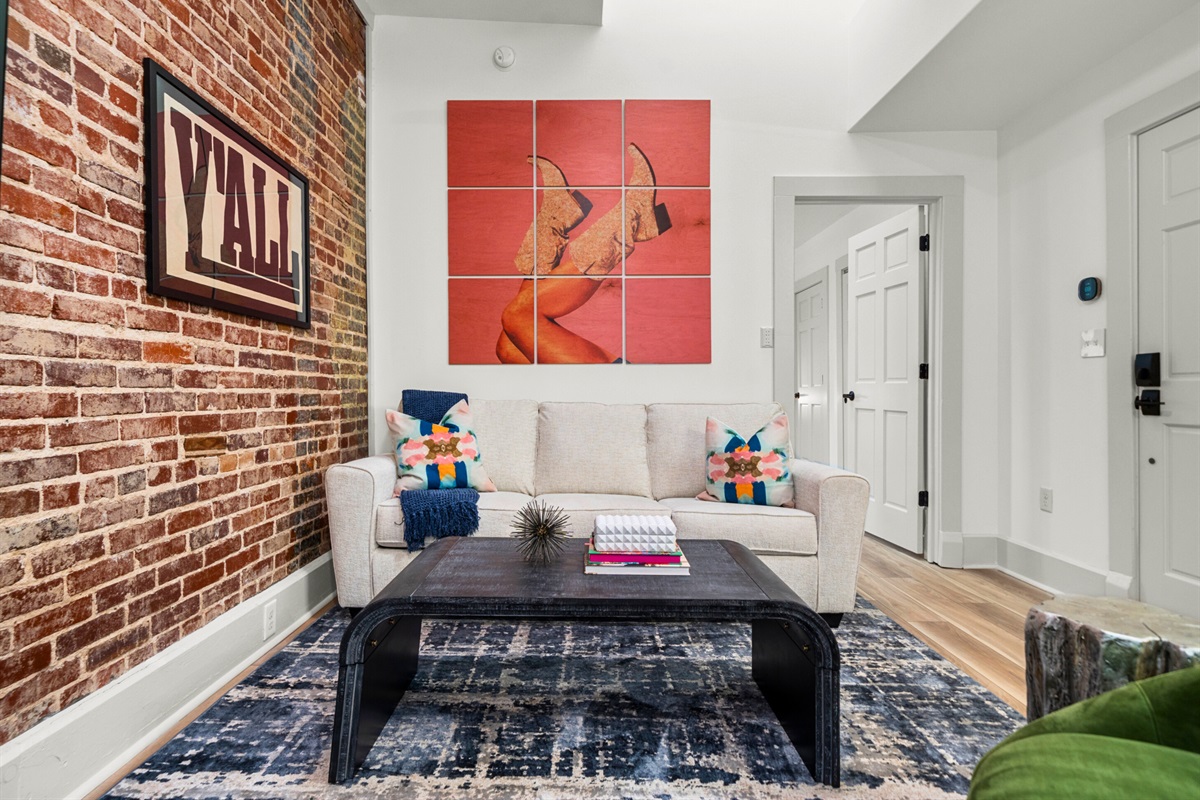 Another view of the living room showcases its cozy seating, eclectic decor, and warm lighting, making it the heart of the loft.