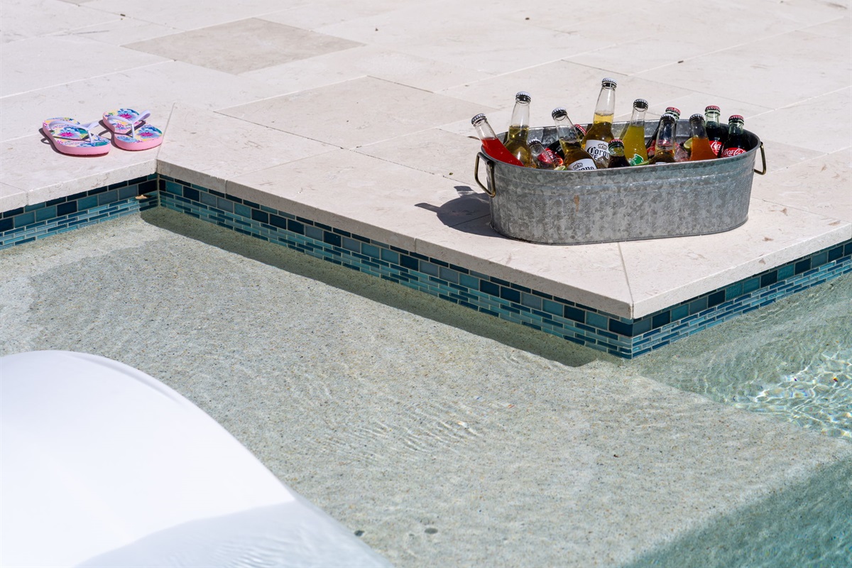 White stone tile, minimalist landscaping, and crisp design make this pool area pop.