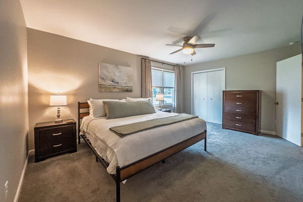 Primary Bedroom, King bed, 55" Smart TV, ceiling fan, two led light nightstands with multiple charging ports, two multi light function lamps, blackout curtains, dresser and closet, private full bathroom.