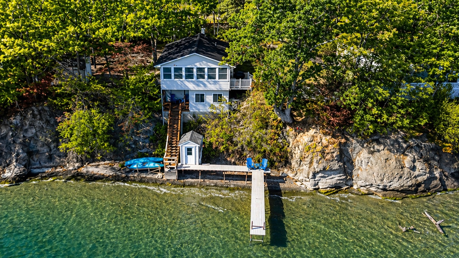 Iconic blue lake house perched above the dock—unmatched water views from every angle