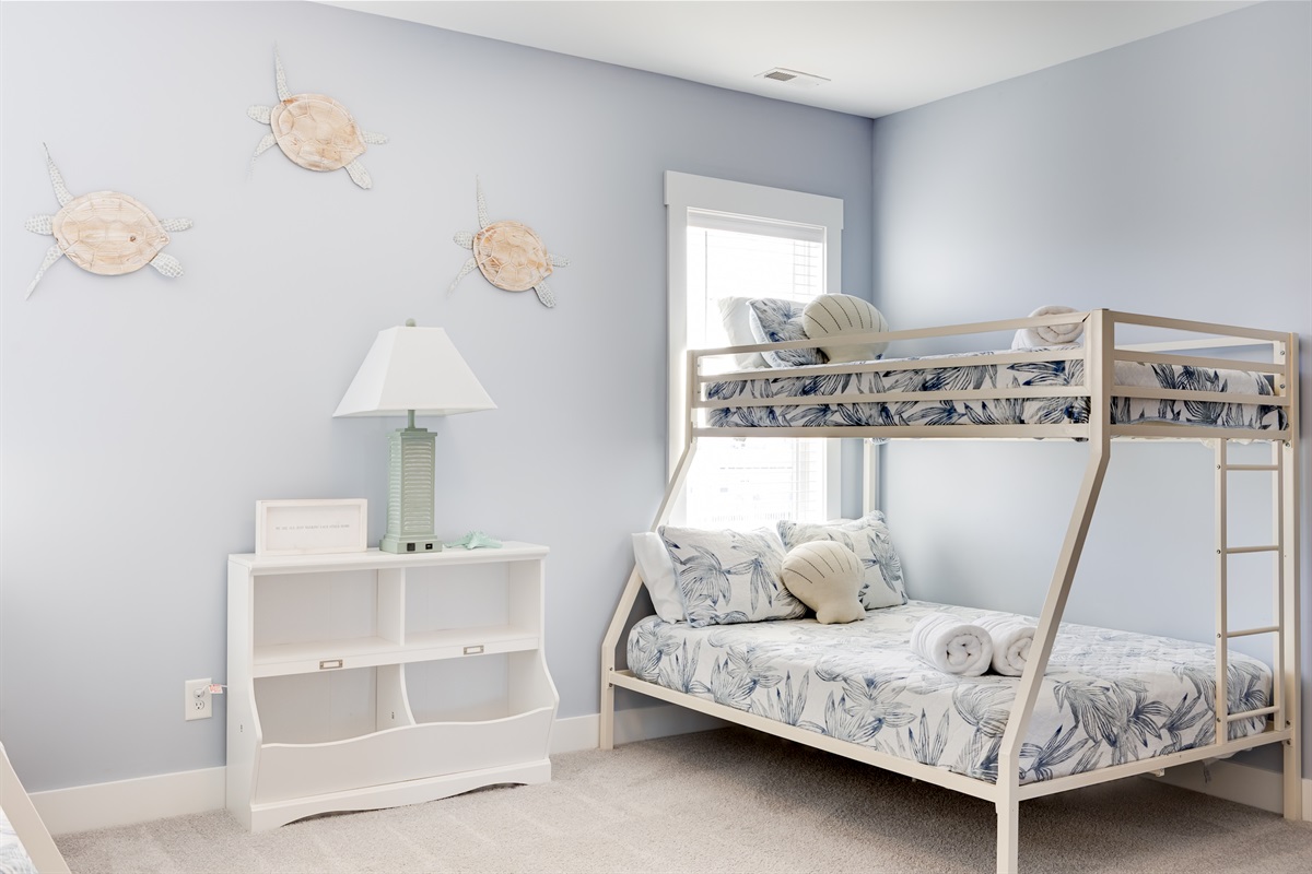 A bright, beachy bunk room designed for families, with coastal touches and plenty of sleeping space