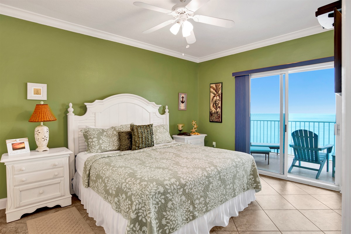 Master bedroom with a king bed, 2 nightstands, ceiling fan, wall mounted 43" Smart TV, direct balcony access, beautiful view of the Gulf and on suite master bathroom.