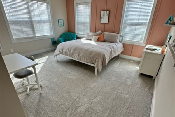 Bright and cheerful, with a super comfy chair for reading and a desk. Private sink and makeup vanity area with access to private toilet and shower rooms, which are shared with bedroom #5.