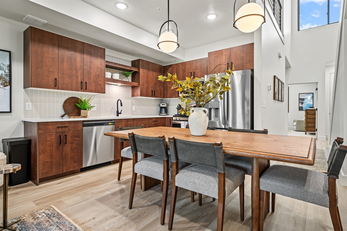 Gather around the warm wood dining table for meals, with an open kitchen designed for style and convenience.