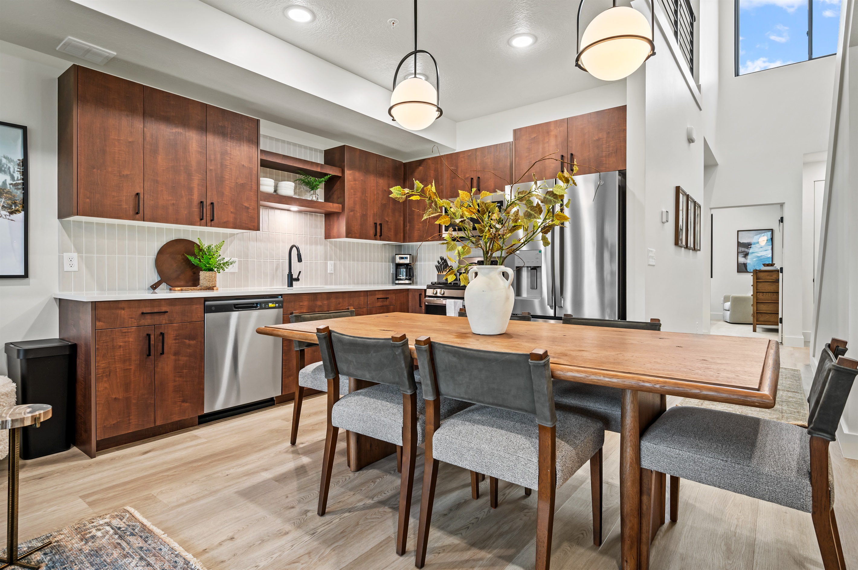 Gather around the warm wood dining table for meals, with an open kitchen designed for style and convenience.