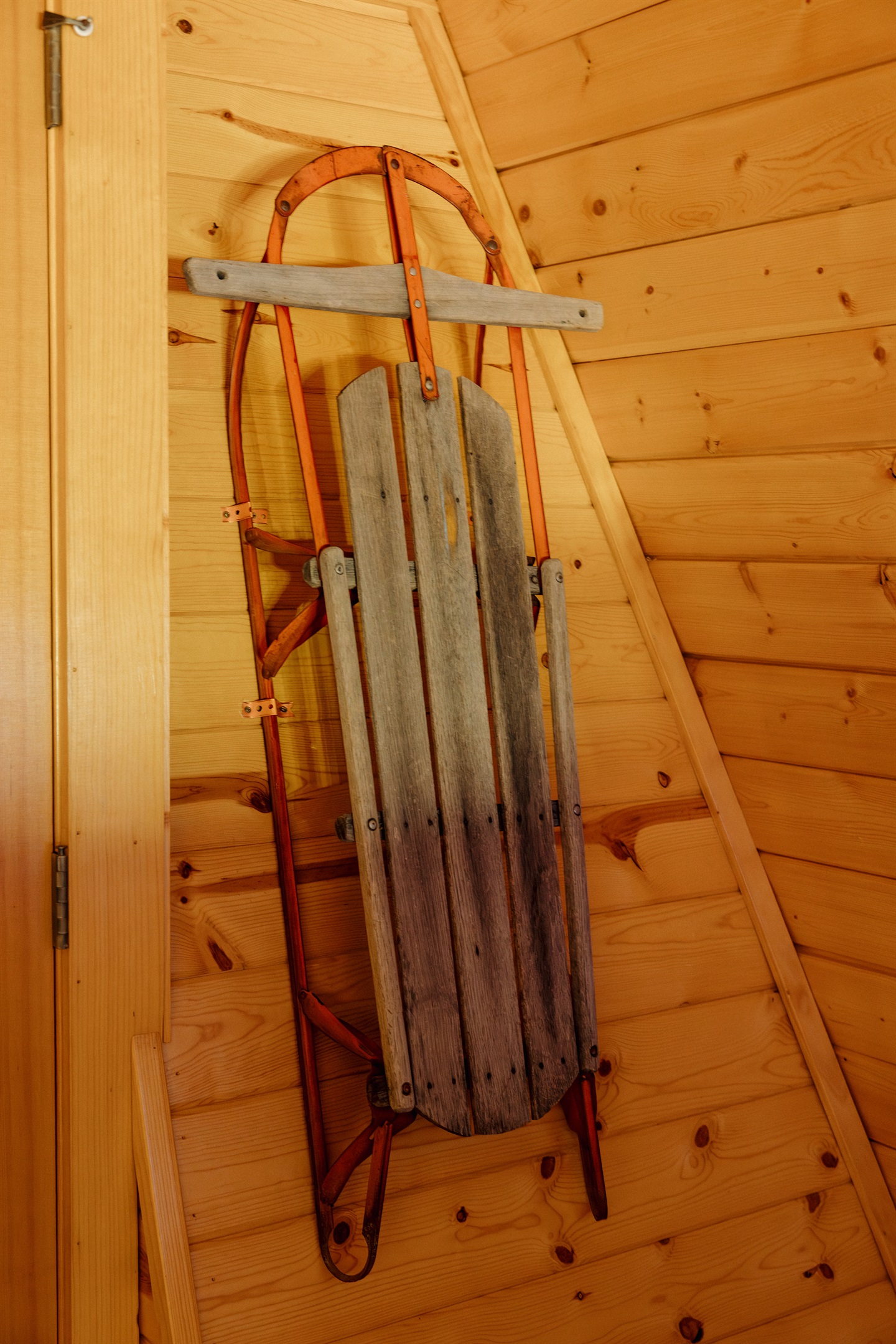 Vintage winter decor like antique sleds adds nostalgic charm at Poppywood Pines. This gothic western Show Low A-frame celebrates mountain heritage with authentic touches throughout, creating a unique White Mountains vacation rental near skiing and hiking.