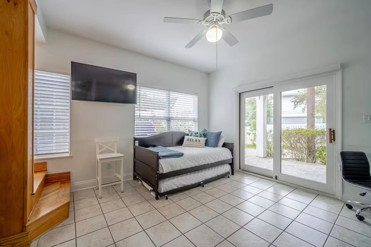 Versatile daybed with trundle setup in the bunk room, providing comfortable extra bedding and a wall-mounted TV for entertainment