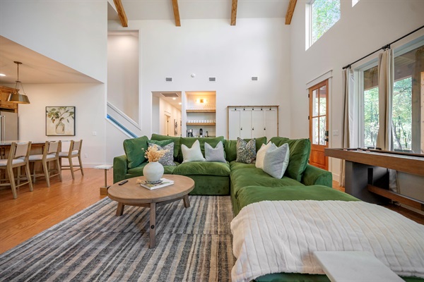 Bright windows, warm wood tones, and a cozy green sectional create the perfect retreat for connection. ✨🌲