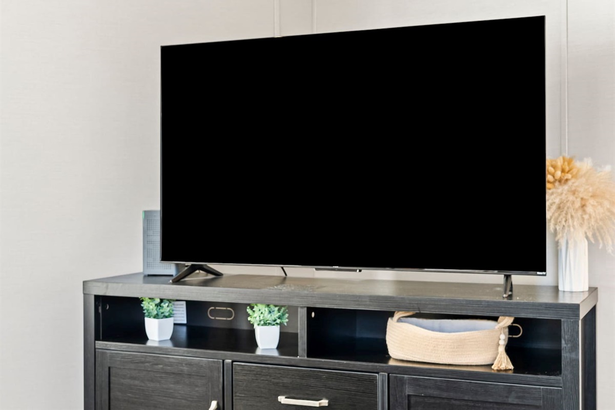Large flat-screen TV setup with storage console—perfect for movie nights and downtime.