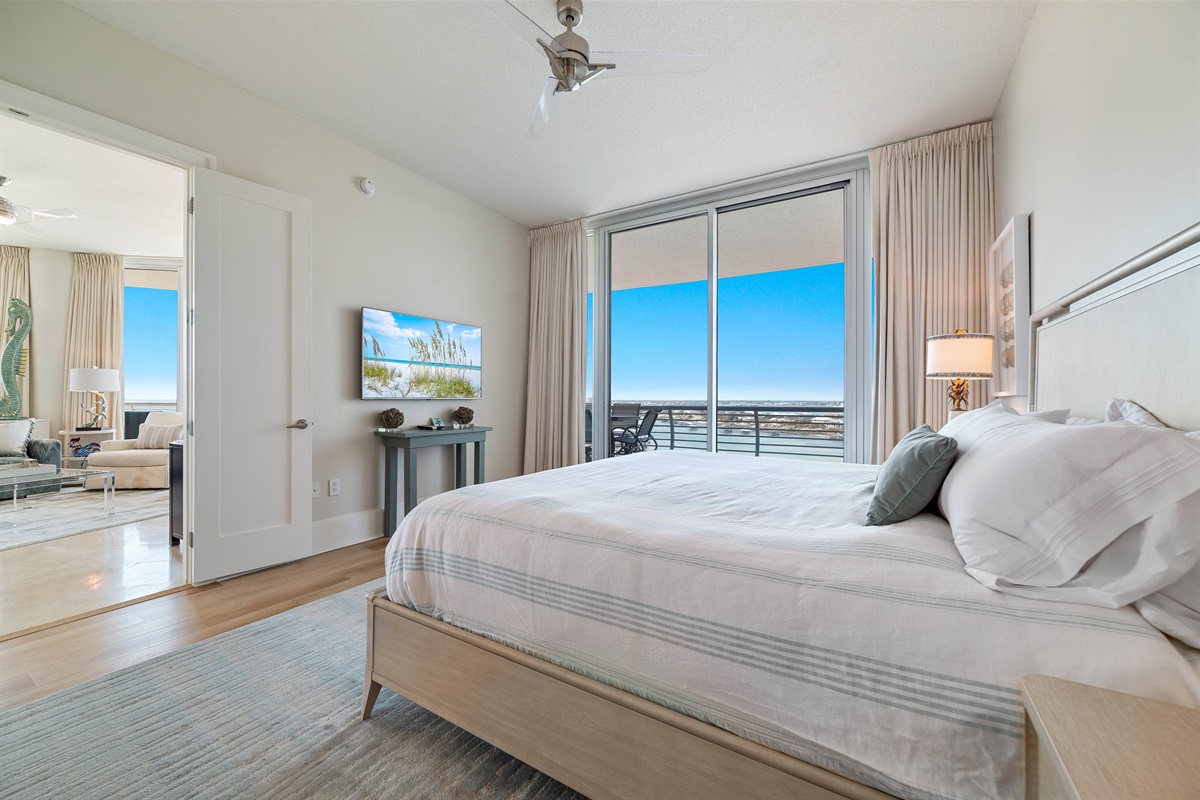Wake up to stunning water views in this beautifully appointed primary bedroom. Seamlessly blending indoor and outdoor living, the expansive sliding doors open to a private balcony, creating a serene and luxurious retreat.