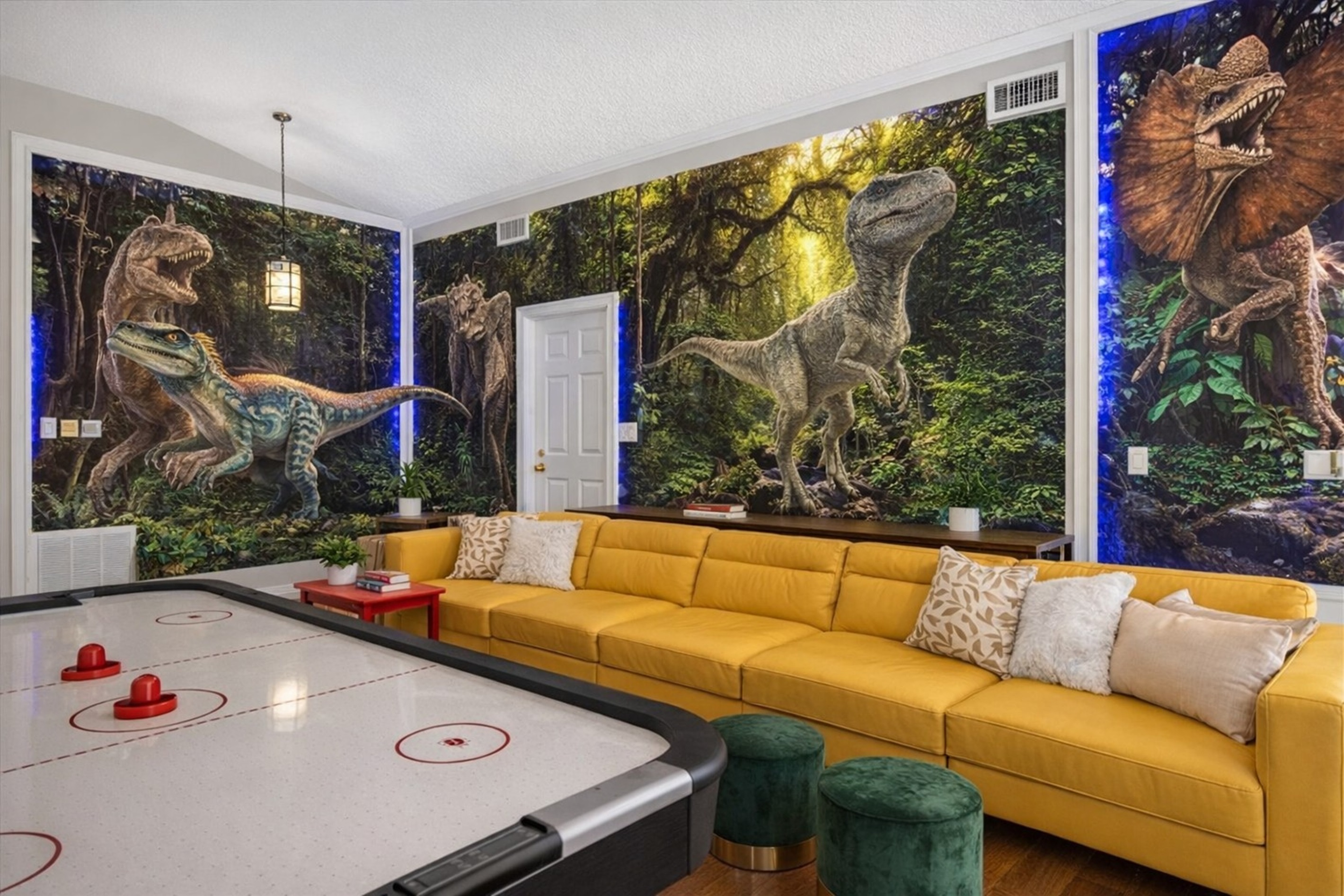 Family-friendly living room with dinosaur-themed wall murals and a large yellow genuine leather sofa.