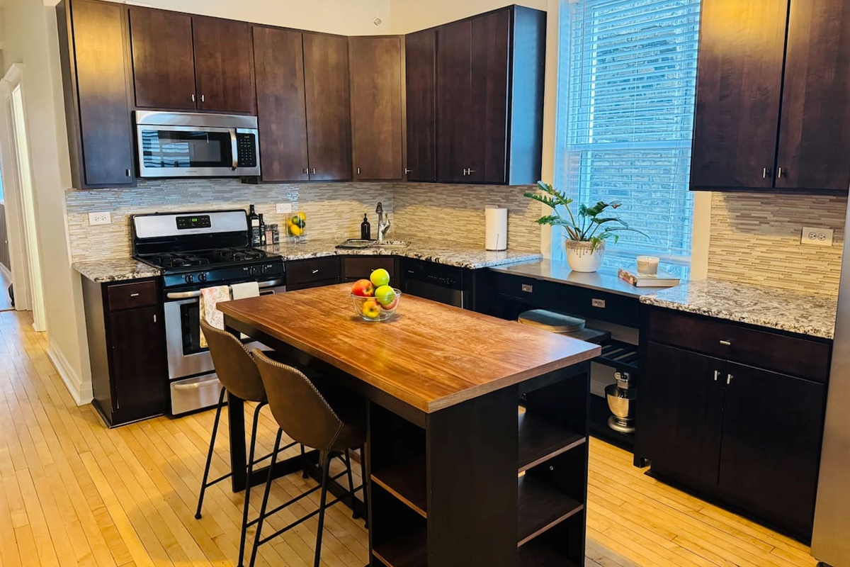 Fully stocked kitchen with large island and modern appliances.