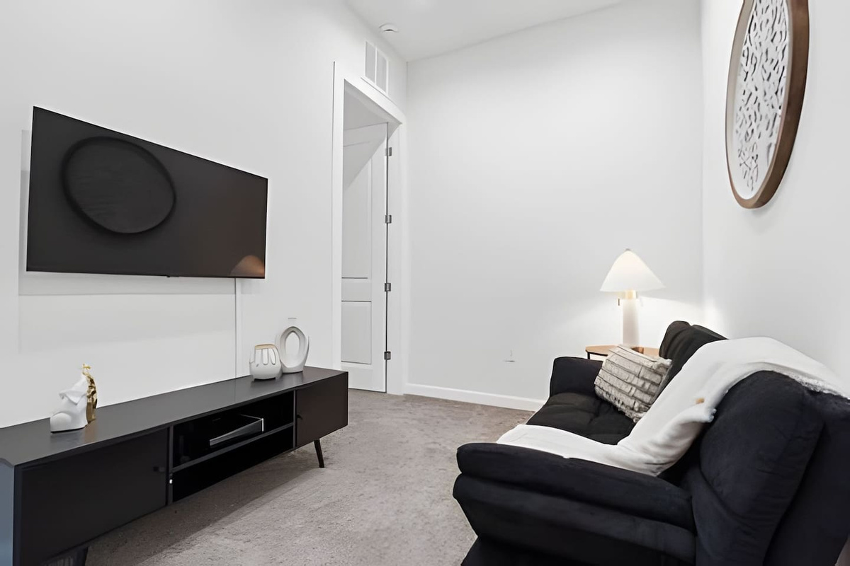 Relax in the spacious living room, complete with a cozy sofa and modern entertainment setup. 