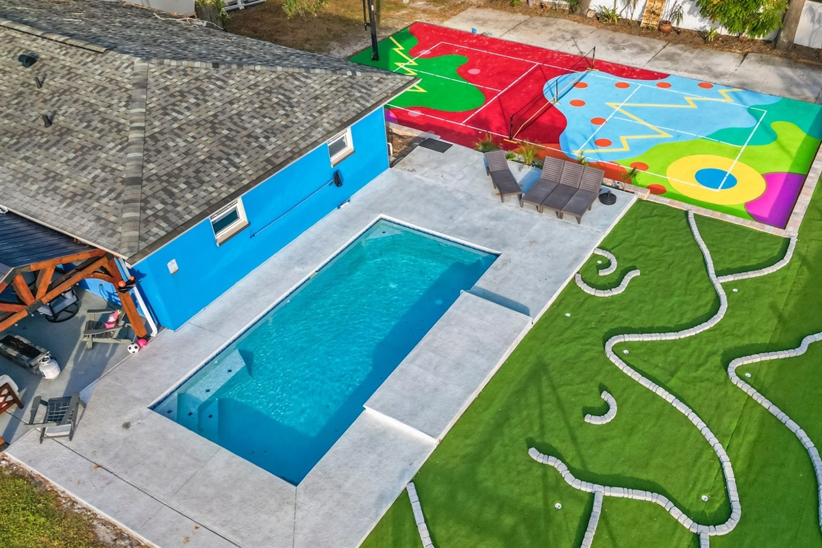 heated saltwater pool pickleball and mini golf in backyard