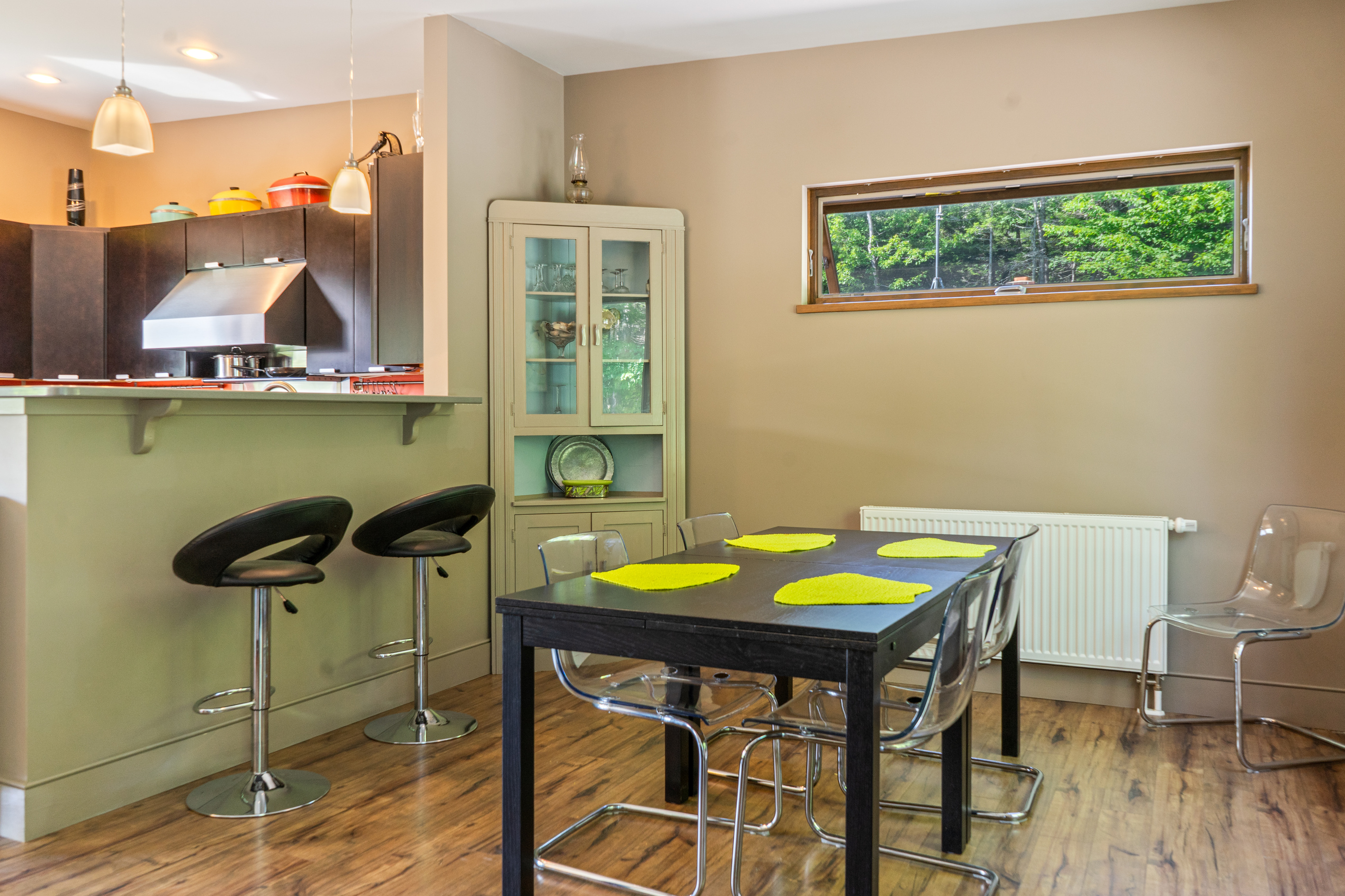 Warm evening ambiance in the main level dining area. This thoughtfully designed space bridges the gourmet kitchen and living area, offering a sophisticated setting for shared meals and storytelling after a day of Acadia adventures.