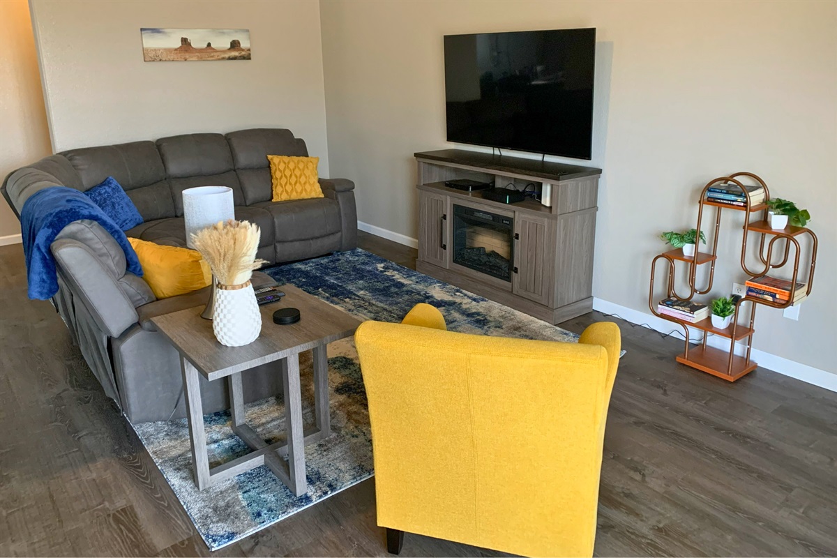 Bright, spacious living room with reclining sectional and colorful accents—perfect for relaxing after a day out. 