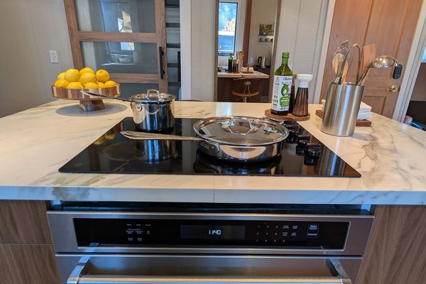 Cook like a pro in this gourmet kitchen, fully equipped with a modern induction cooktop, premium All-Clad stainless steel cookware, and plenty of marble counter space for meal prep.