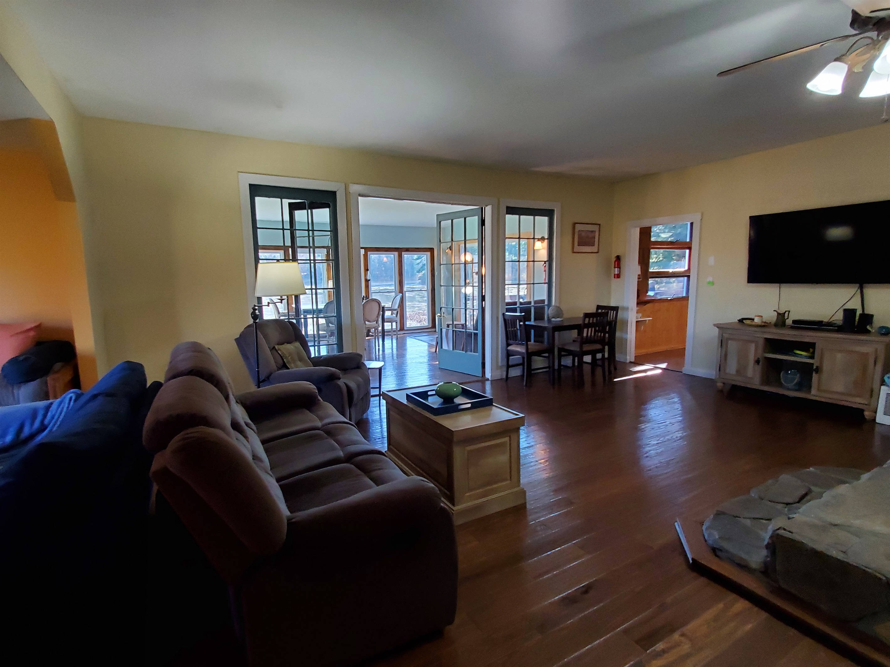 Nature's Hidden Treasure French doors open from living room to sunroom overlooking the waterfront.