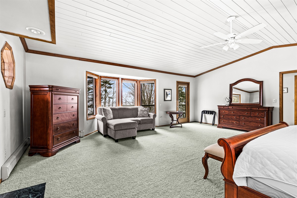 This roomy primary bedroom features a private deck, sofa sleeper, and a bathroom conveniently connected just off the room. A cozy and versatile space designed for comfort, privacy, and an easy stay.