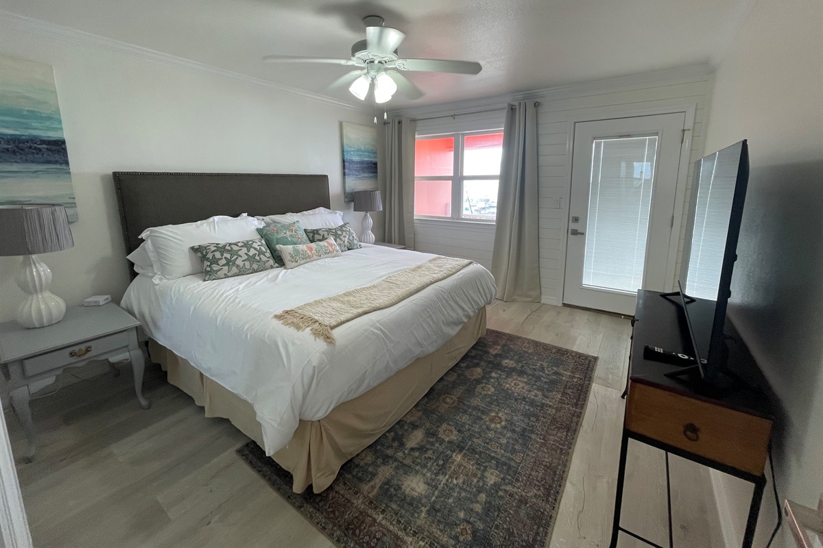 Master bedroom with king bed and smart tv plus access to balcony with oceanview