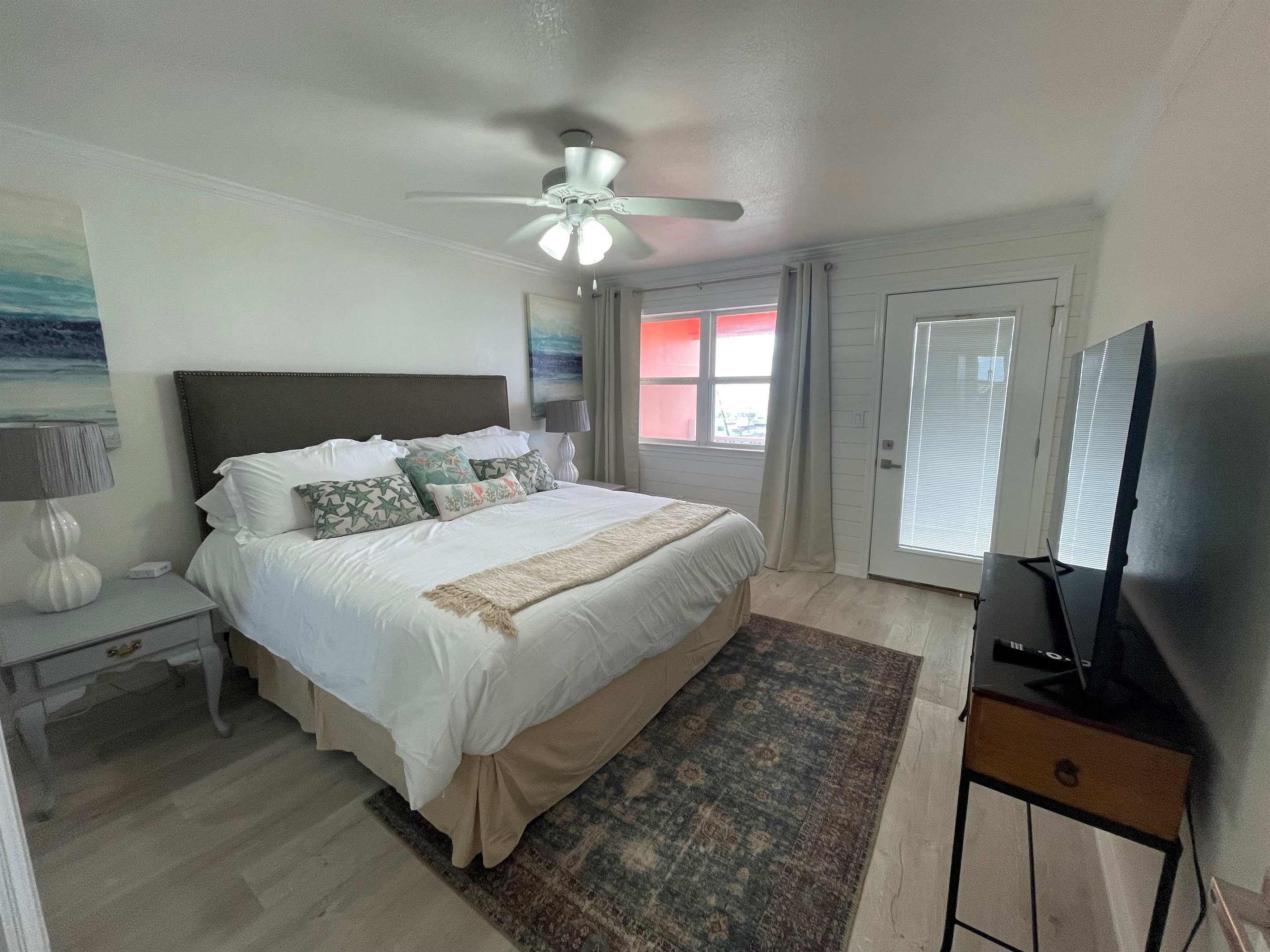 Master bedroom with king bed and smart tv plus access to balcony with oceanview