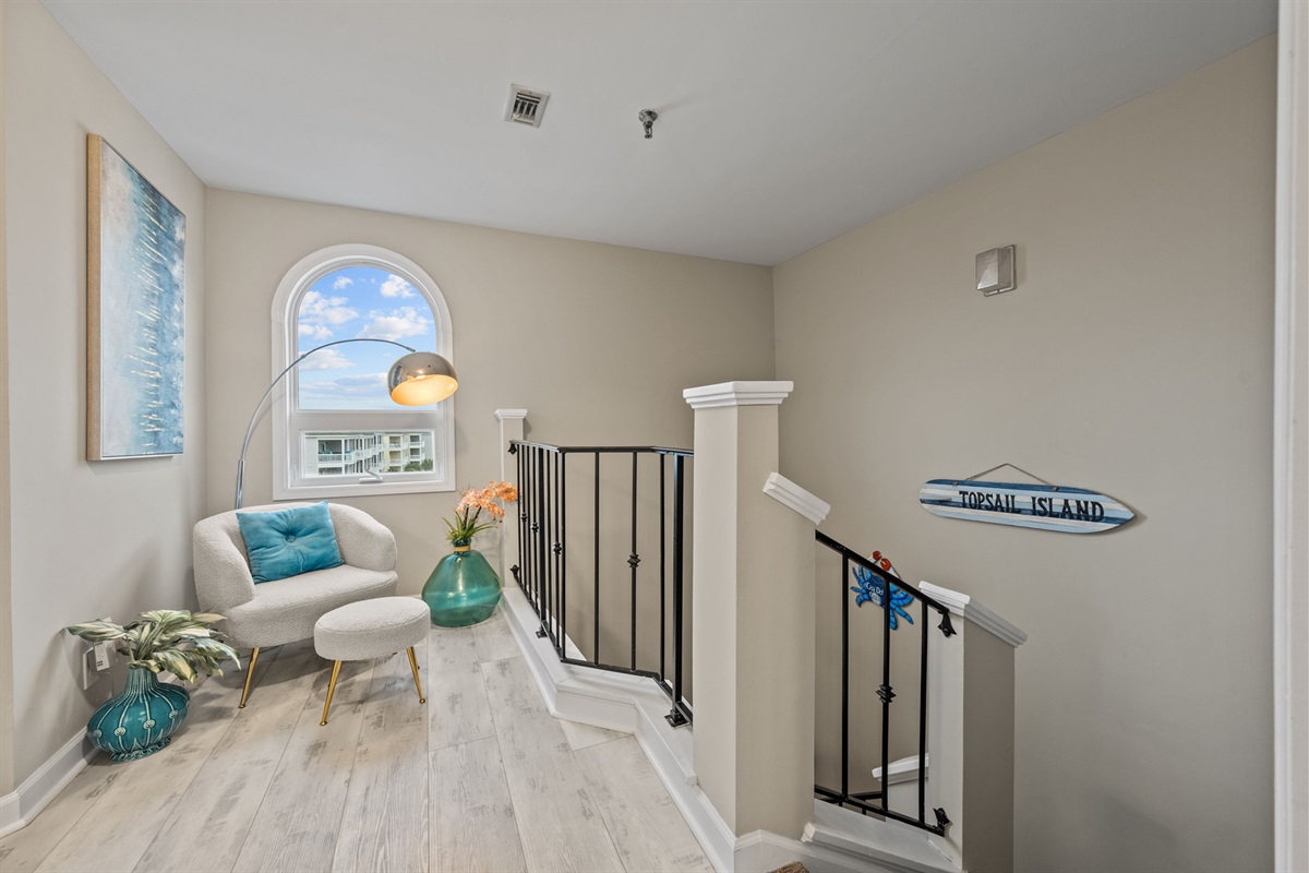 Bright upstairs lounge with ocean views, the perfect nook for morning coffee or a quiet read