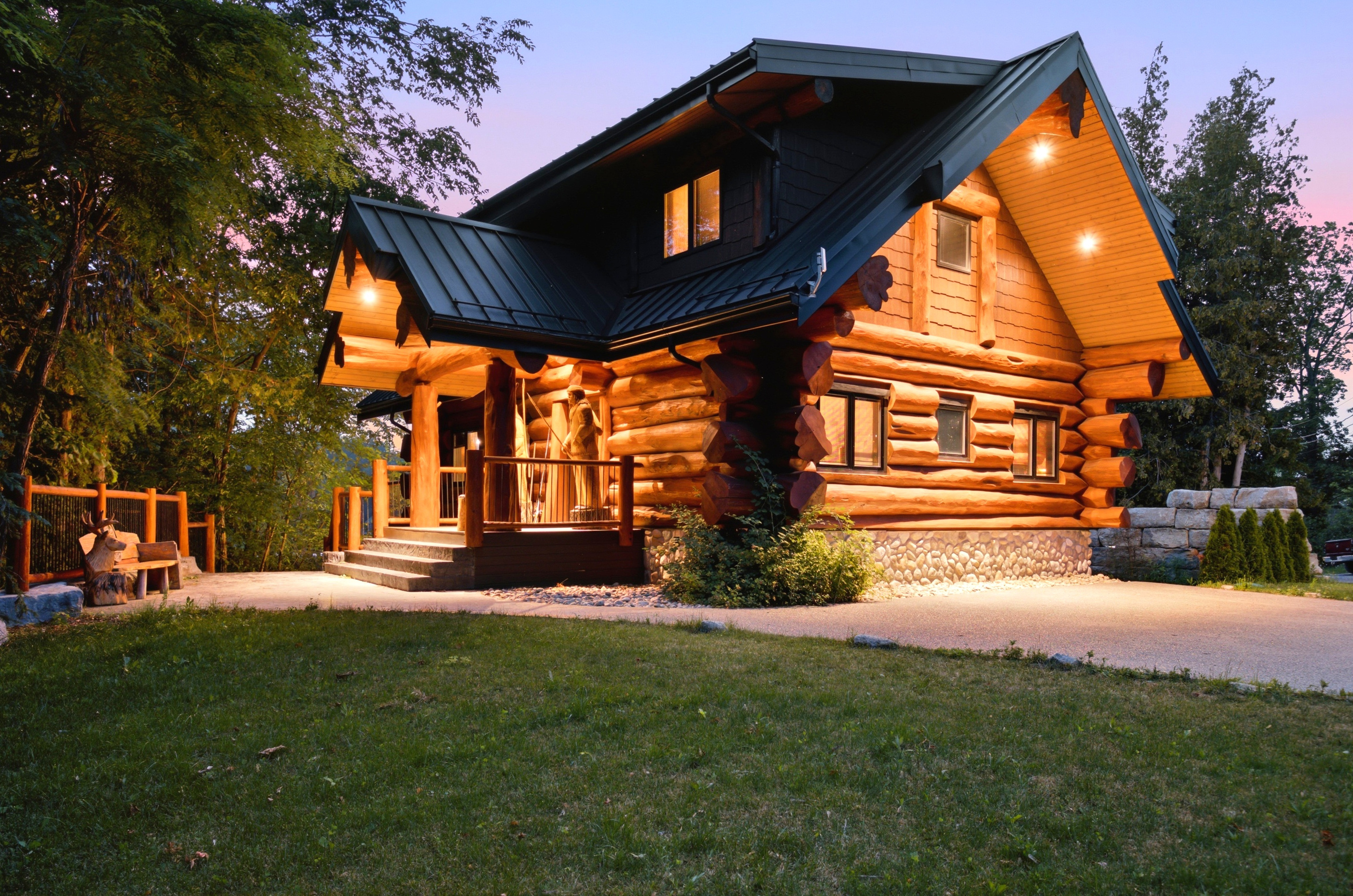 Bear Lodge exterior at twilight with warm lighting and a spacious front lawn