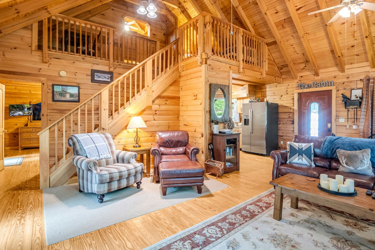 Inviting reading nook and seating area beneath the staircase leading to the third level of the cabin
