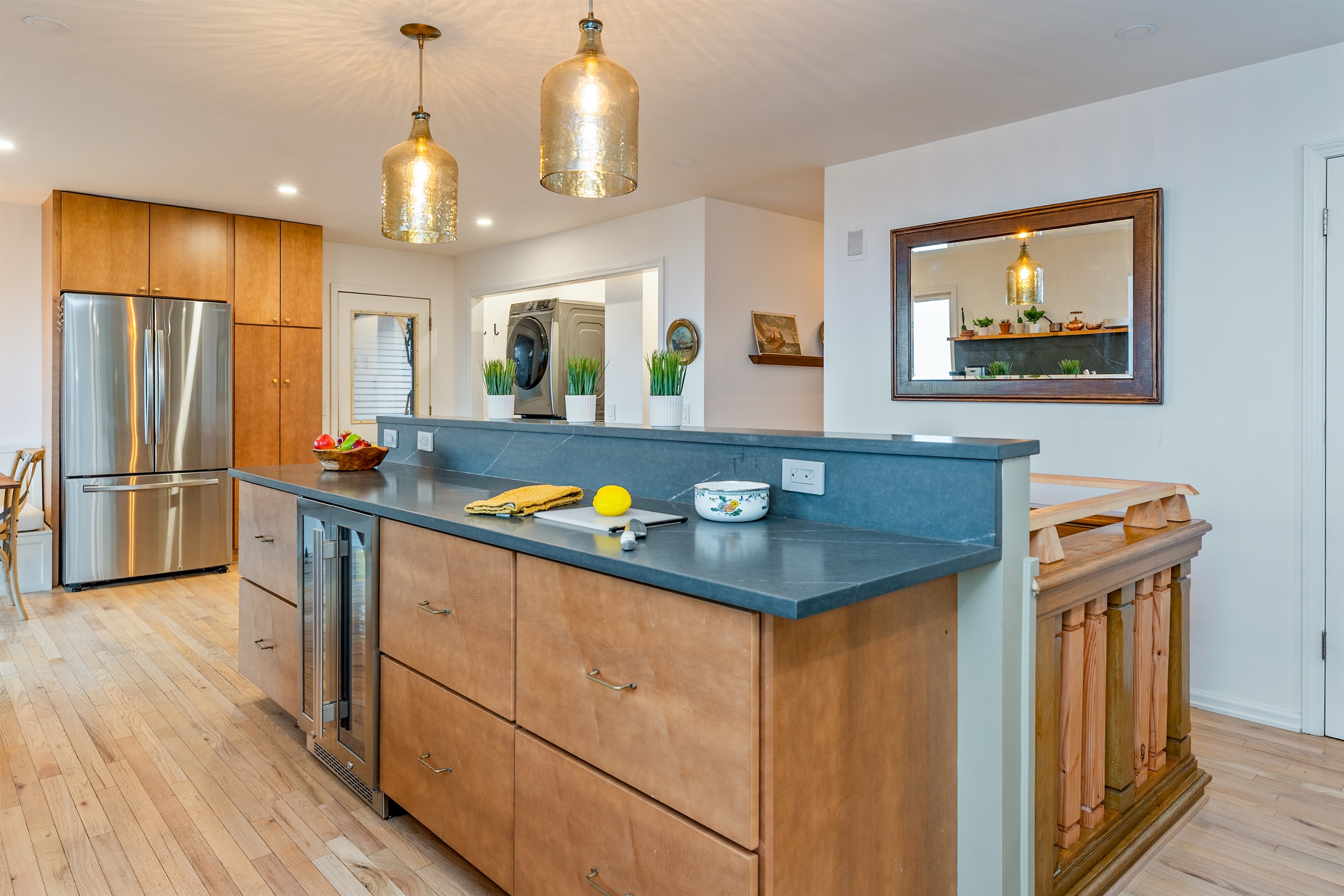 The heart of the home features a large island, pendant lighting, and a wine fridge—perfect for entertaining in style