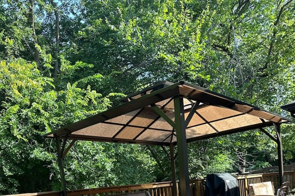 Covered patio with grill for outdoor dining and entertaining.
