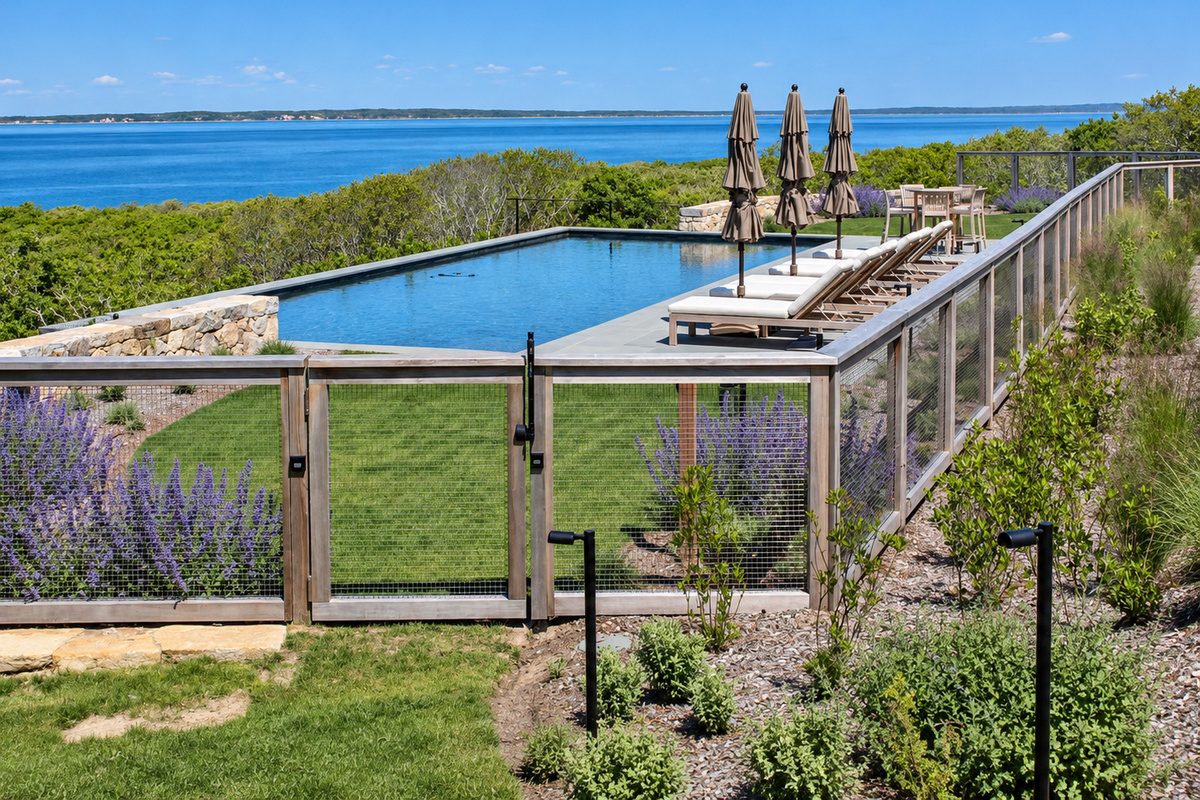 Fenced pool with lounge chairs and water views