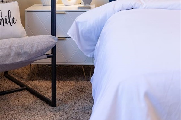 Cozy, spacious room with a queen-sized bed, TV, and a dedicated working space.