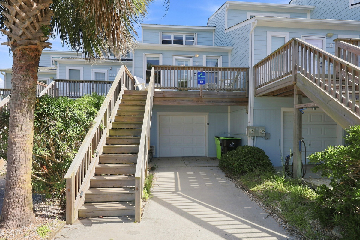 Welcoming coastal architecture complete with private entry stairs and lush tropical landscaping.