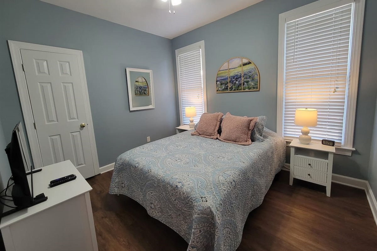 2nd bedroom with queen bed, TV and closet.