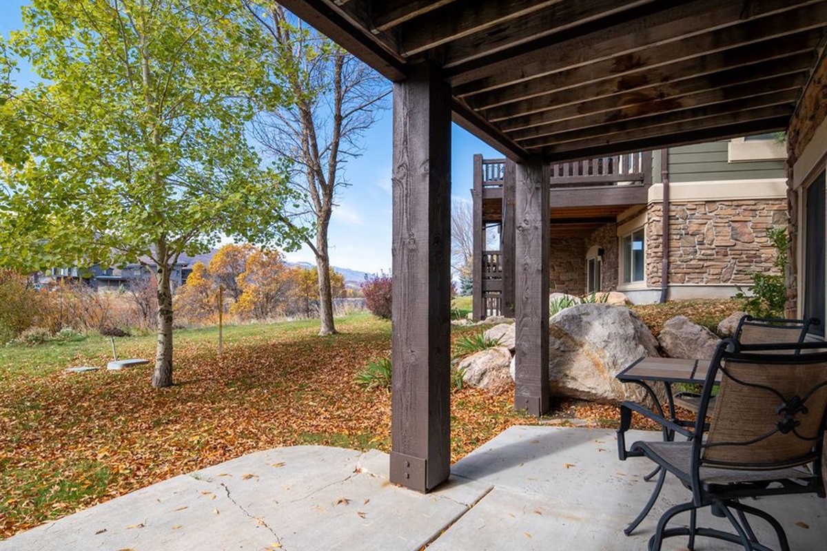 Covered patio retreat surrounded by nature—perfect for morning coffee or evening relaxation.