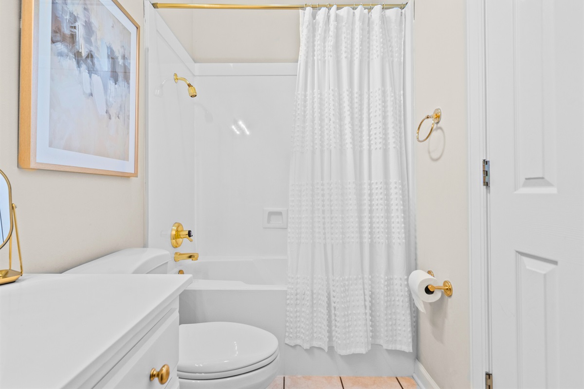 A full bath with bright tones and a classic layout &mdash; ready for your stay.