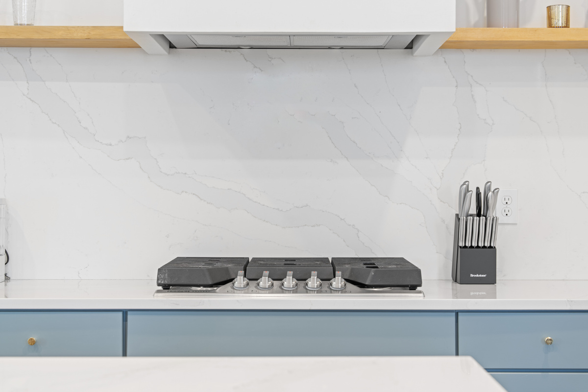Five gas burners and a marble backsplash worth cooking in front of. Whether it is a big Sunday sauce or grilled cheese at midnight, this is where the family recipes get made and the house fills with something wonderful.