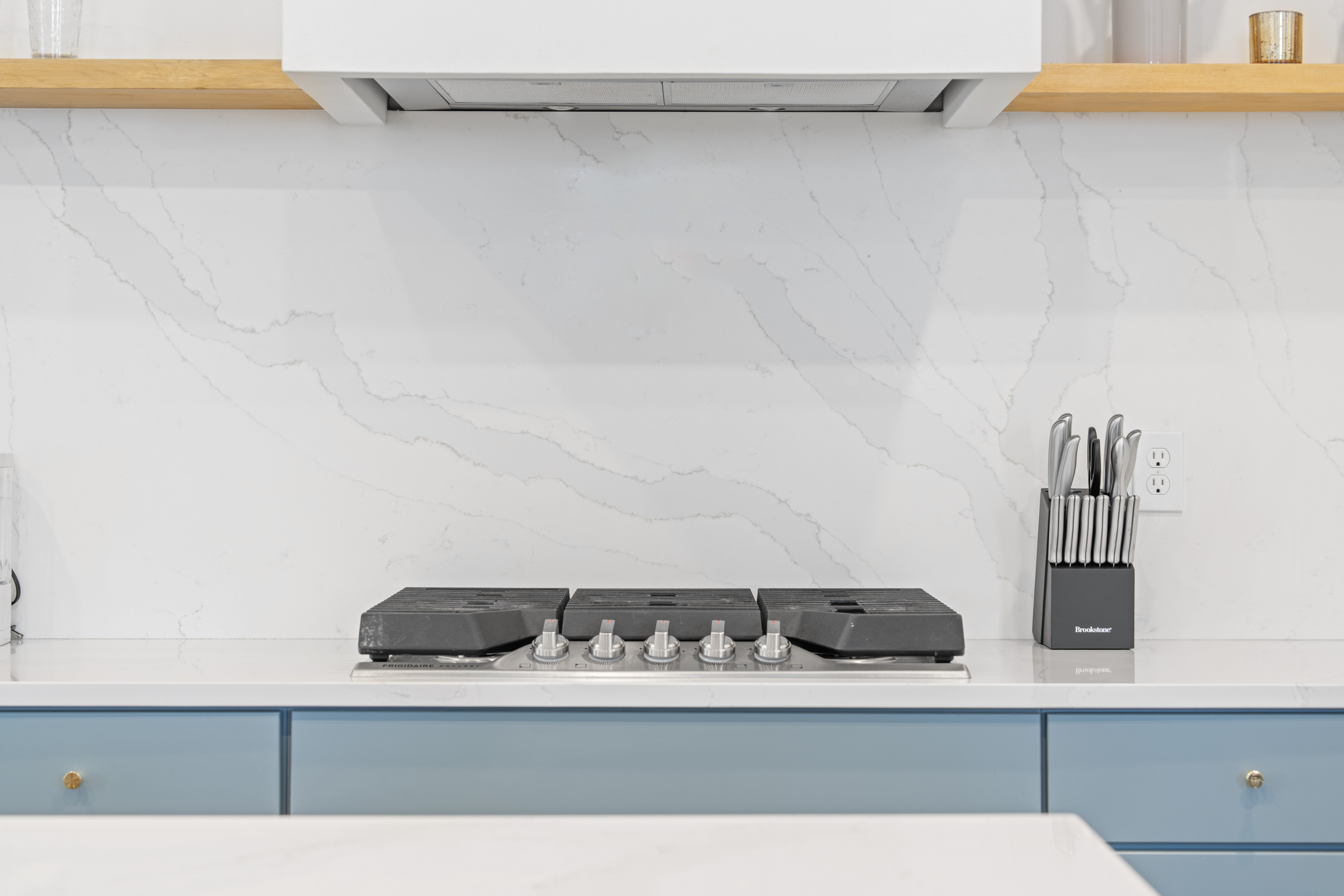 Five gas burners and a marble backsplash worth cooking in front of. Whether it is a big Sunday sauce or grilled cheese at midnight, this is where the family recipes get made and the house fills with something wonderful.