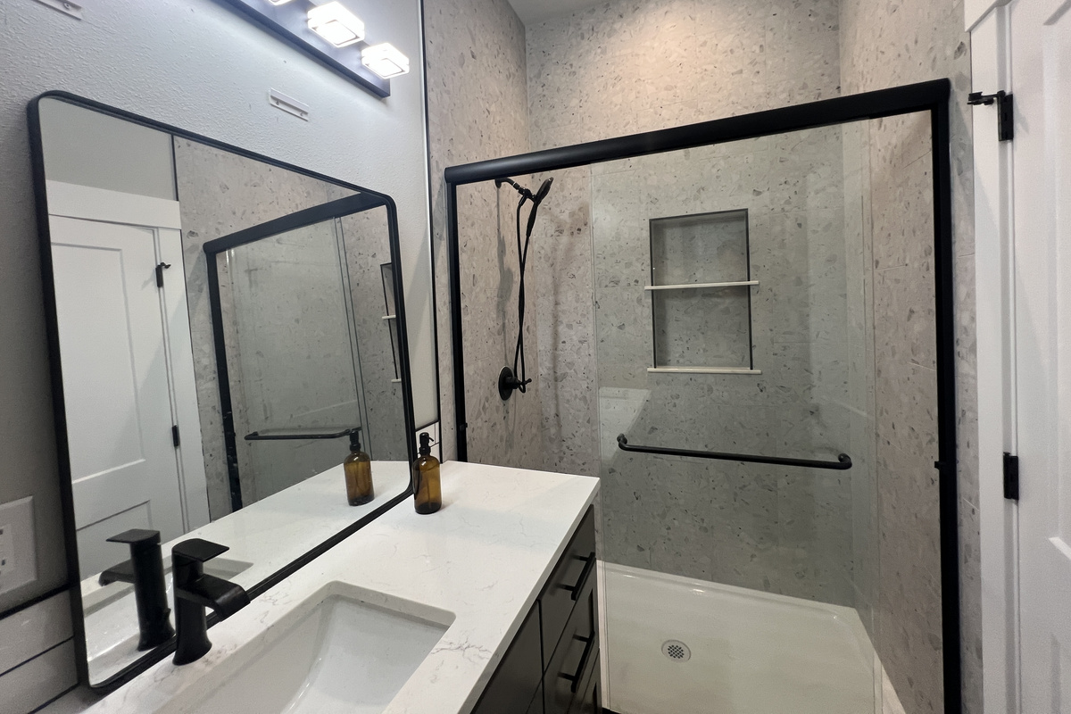 The primary's double-vanity bath — spacious walk-in shower, designer tile and room for two to get ready at once.