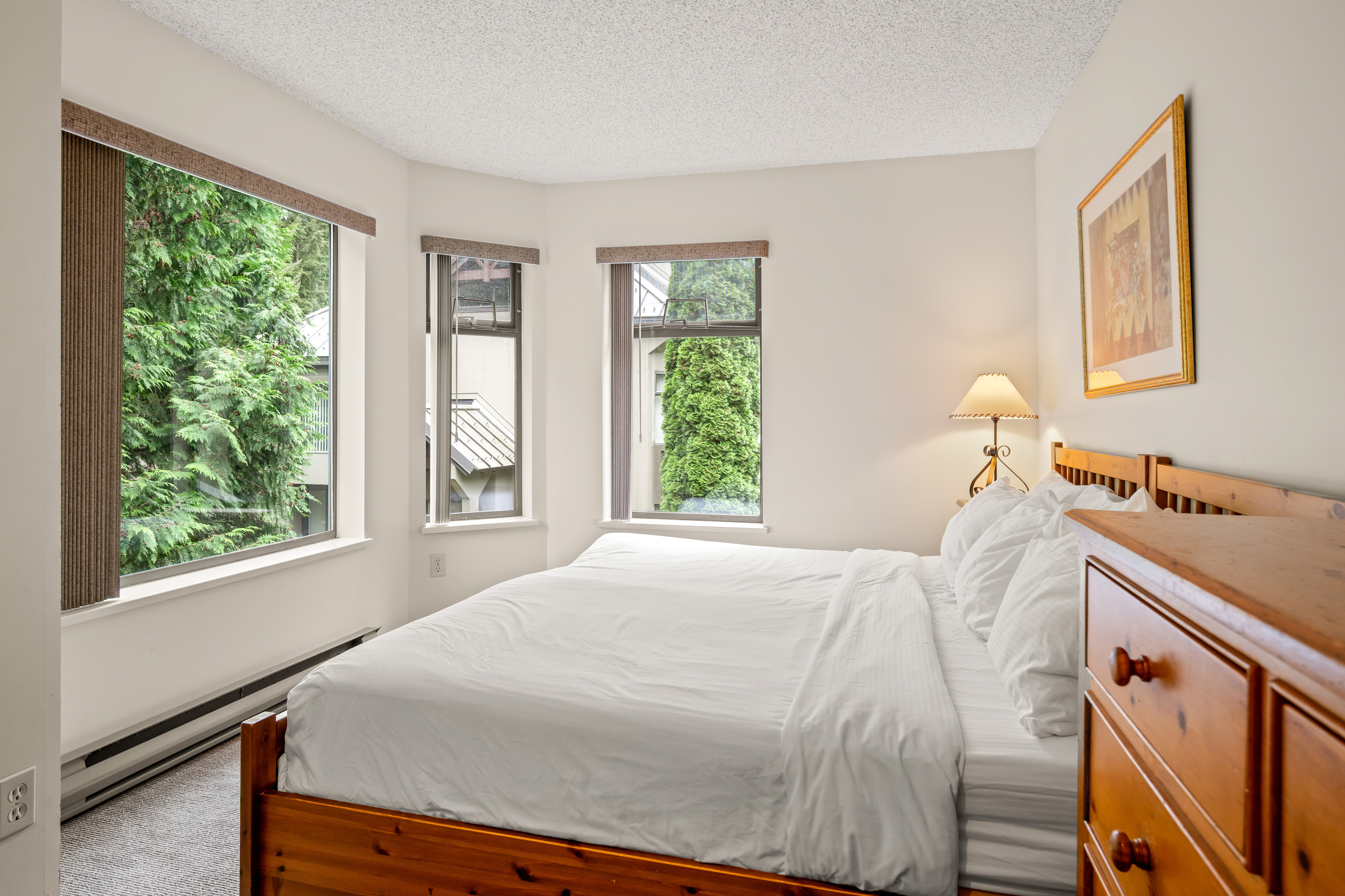 Bedroom 2 with a split king that can be set up as two twins on request, a wood dresser and bedside lamps on the 2nd floor.