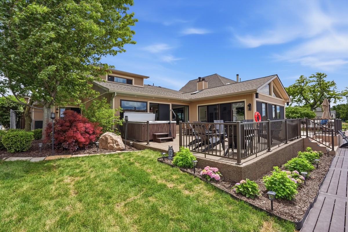 Spacious backyard patio with a hot tub, outdoor seating, and well-maintained landscaping. Private and relaxing outdoor space perfect for entertaining, unwinding, and enjoying warm-weather stays.