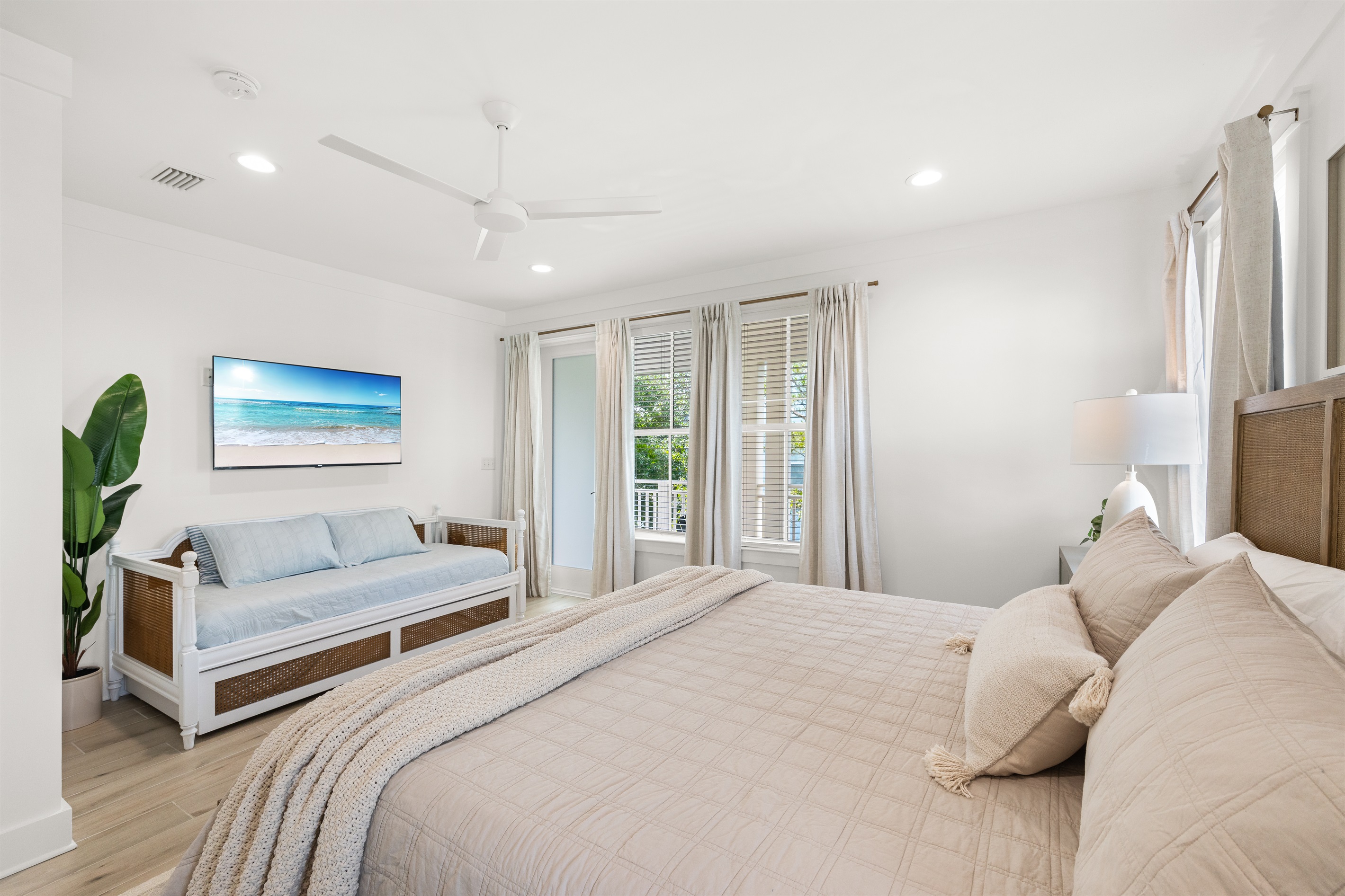 The spacious upstairs king suite offers a relaxing coastal retreat with a king bed, a daybed with a pull-out trundle provides extra sleeping space for children or additional guests.  Doors open to a private balcony furnished with two Adirondack chairs.