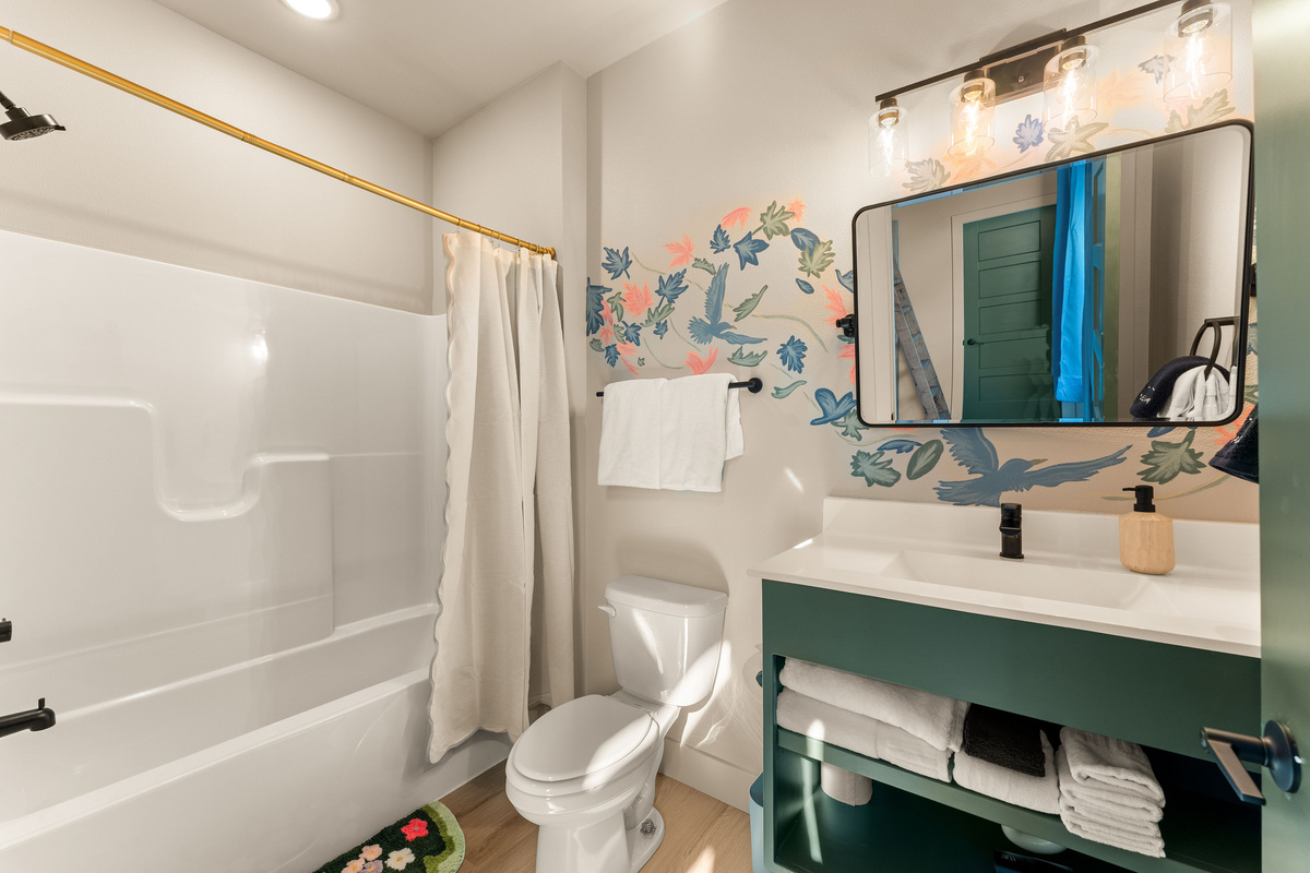 Full Bathroom with Tub/Shower
    Bright, cheerful, and thoughtfully designed, this full bathroom features a tub and shower combination, fresh towels, and colorful botanical details that carry the home’s whimsical style into every corner.