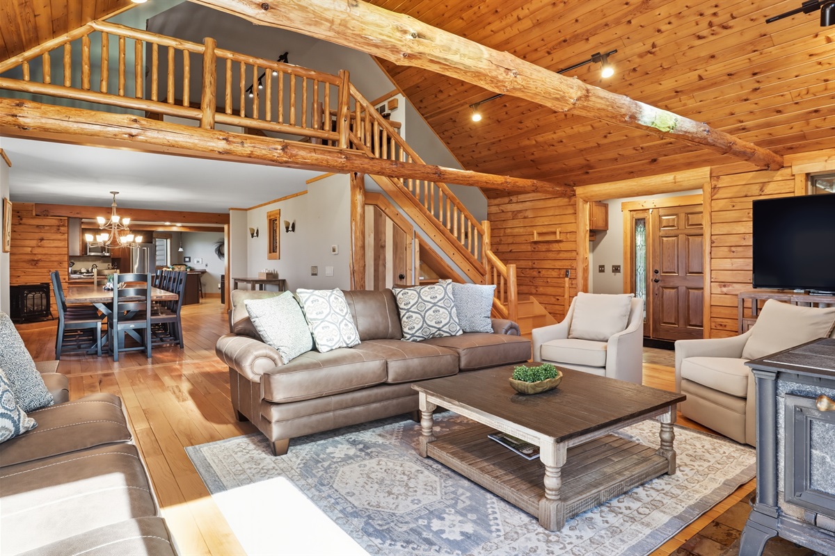 Lofted living room featuring log cabin charm and open layout.